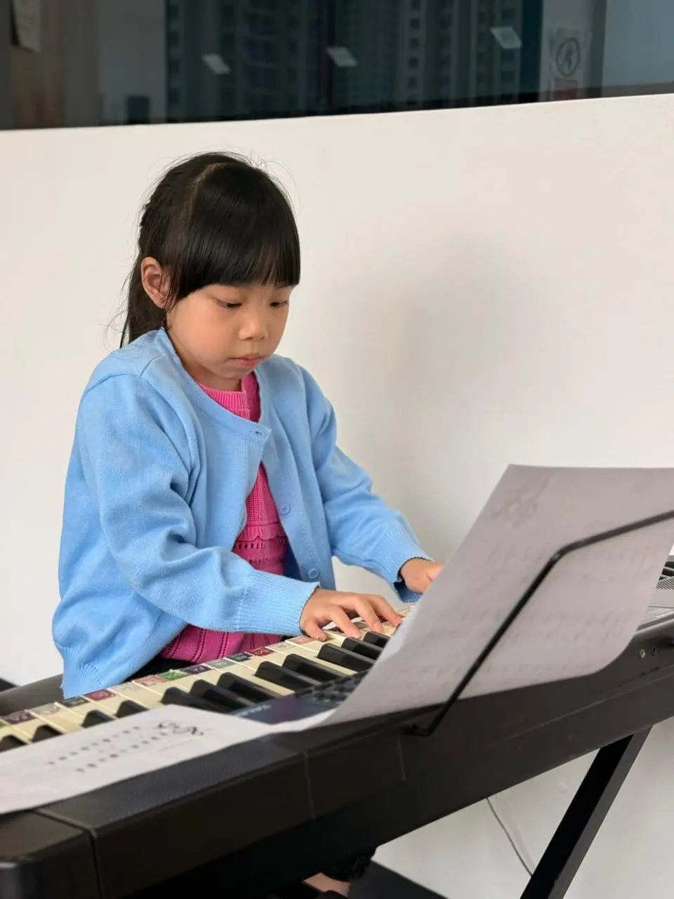 niña aprendiendo a tocar el piano en instituto sol